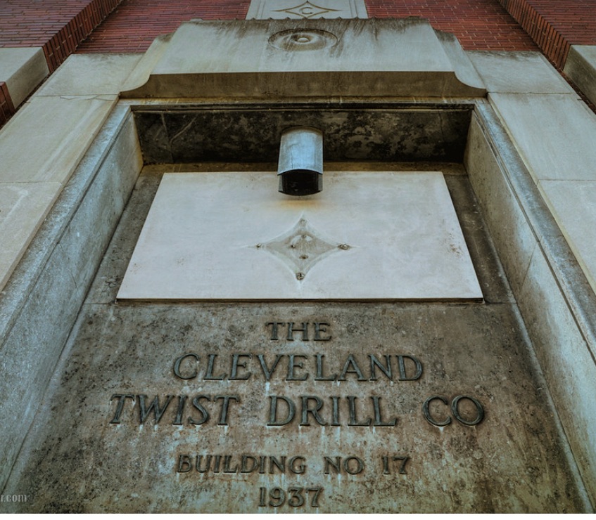 Close-up of a stone plaque on a building exterior that reads 'THE CLEVELAND TWIST DRILL CO BUILDING NO 17 1937' with decorative elements.