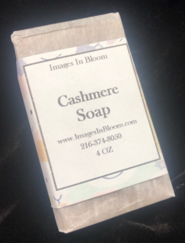 A wrapped bar of cashmere soap with a label displaying the product name, brand 'Images In Bloom,' website, phone number, and weight.